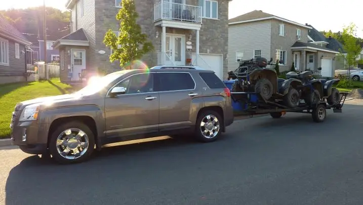GMC Terrain towing a trailer with two ATVs on it