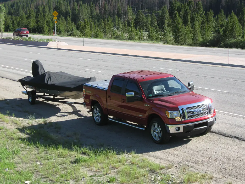 truck towing boat trailer on road