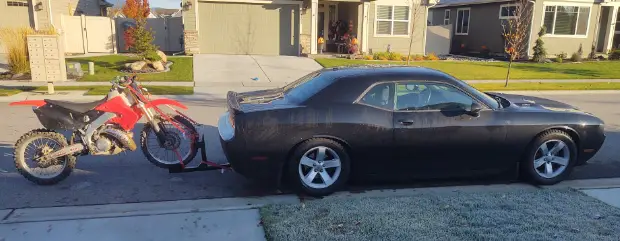 dodge charger towing a dirtbike trailer